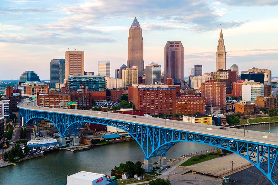 Cleveland OH - Aerial View of Downtown Cleveland Ohio Next to the River with Bridge and a Sunset Sky