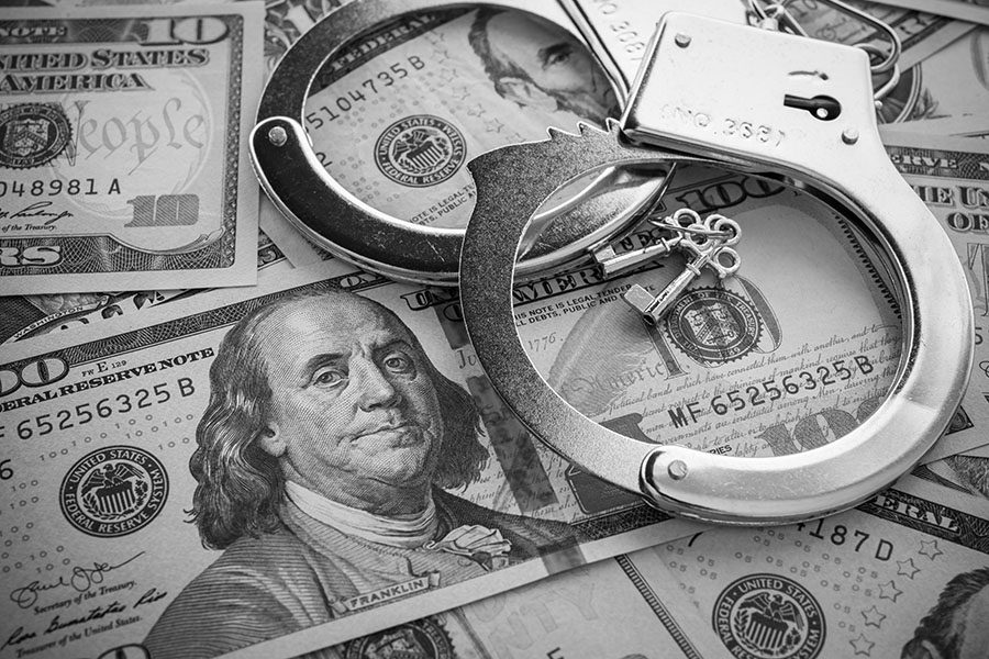 Crime Insurance - View of Handcuffs with Keys Laying on Top of Money